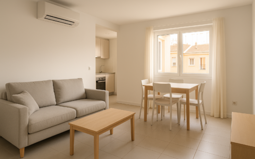 Salón comedor luminoso en Madrid, listo como piso para alquilar, con aire acondicionado, mobiliario neutro y cocina al fondo.